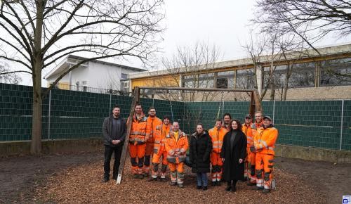 Gruppenbild: Die Leiterin des Fachbereiches Soziales, Bildung, Kultur und Sport, Linda Hoti (vorne rechts), die Leiterin des Friedrich-Fröbel-Kindergartens Nadine Neickert (vorne links) sowie der Leiter des Bauhofs Paul Stumpf (links) mit seinem Team vor dem neuen Zaun.