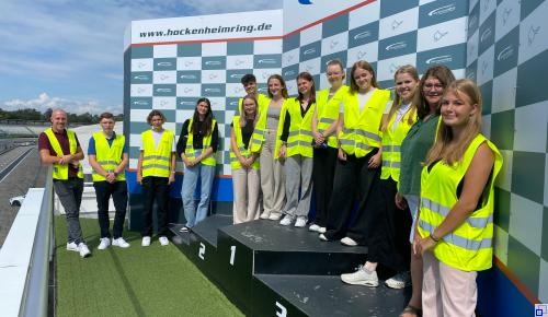 Drei Personen in Halloweenoutfits vor einer Halloweendekoration