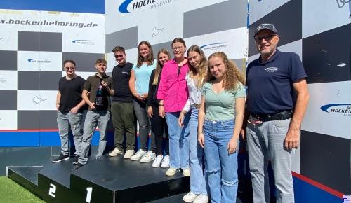 Drei Personen in Halloweenoutfits vor einer Halloweendekoration